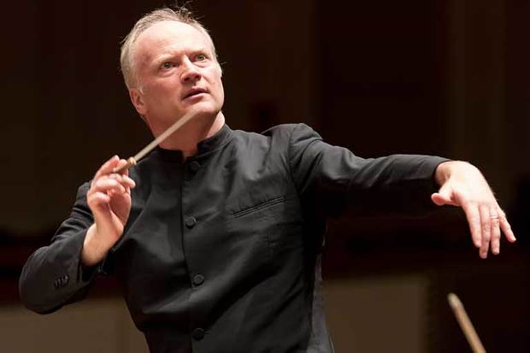 NSO Music Director Gianandrea Noseda conducting and gazing up and off camera.