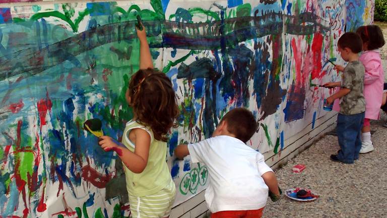 Kids work together to paint a colorful wall