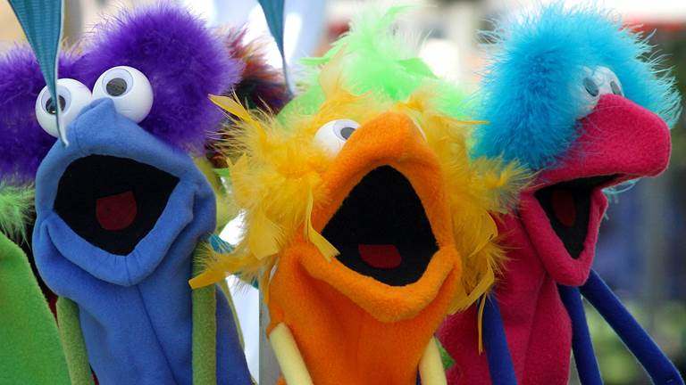 Three colorful hand puppets that resemble friendly monsters