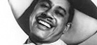 A black-and-white photo of jazz vocalist and bandleader Cab Calloway. Cab is smiling while wearing a wide-brimmed hat.