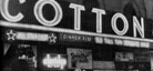 A black-and-white photo of the exterior of the Cotton Club, including its marquee sign.