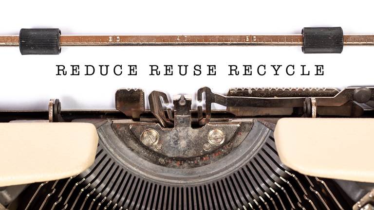 A vintage typewriter that has typed "Reduce, Reuse, Recycle."