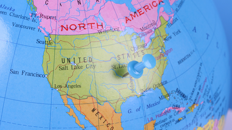 A globe of North America with a push-pin near St. Louis, Missouri.
