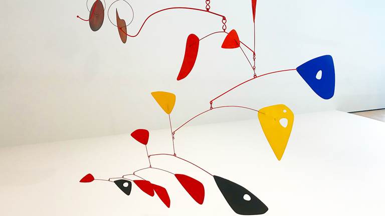 A mobile with different shapes and colors suspended from the ceiling.