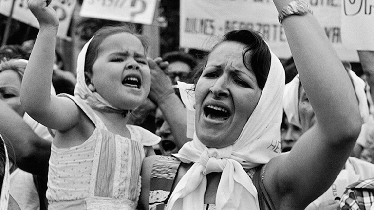 A black and white photograph of a mother and young daughter at a protest.