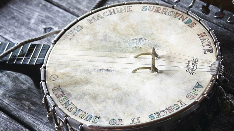 Pete Seeger's banjo with writing on it that says, "This machine surrounds hate and forces it to surrender."
