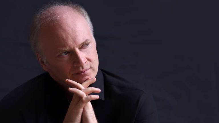 Gianandrea Noseda looks to the side of the camera.