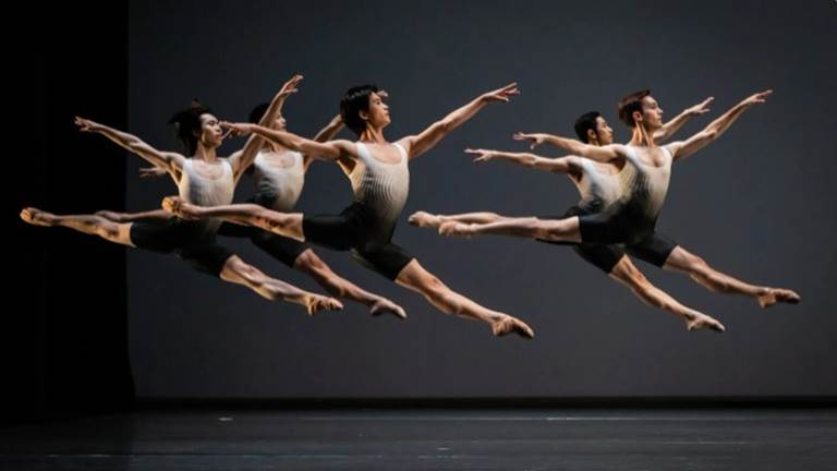 Ballet dancers leaping in unison.