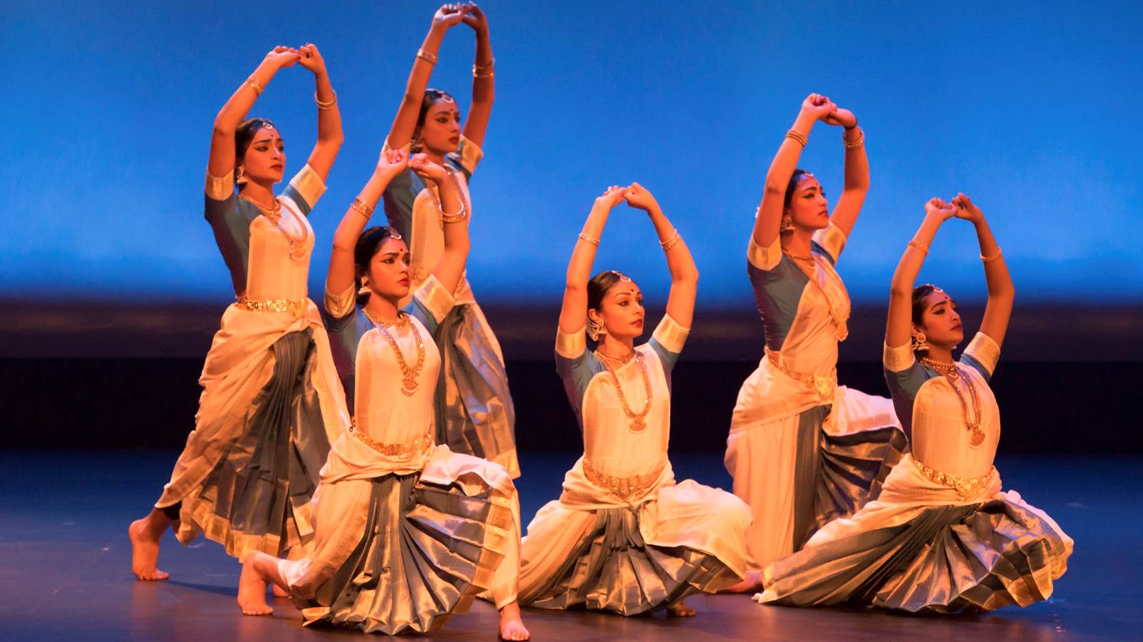Six dancers wearing peach dresses with Kalanidhi Dance