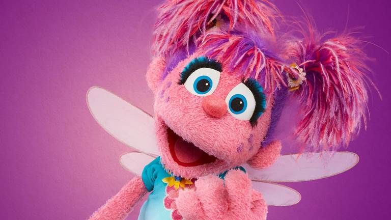Sesame Street muppet Abby Cadabby against a pink purple background
